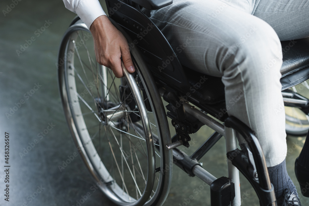 Obraz premium cropped view of young handicapped businessman sitting in wheelchair