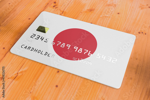 Plastic credit or bank debit card with country flag of Japan national banking system isolated on wooden table close up concept 3d rendering image photo