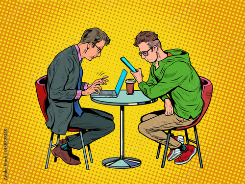 two men in a cafe are working on a laptop and a smartphone. Freelance in a restaurant