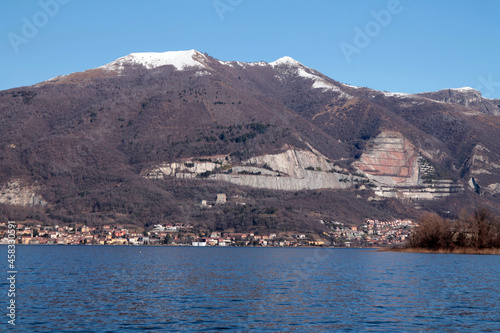 The pit with the snow on the top over the lake in Italy