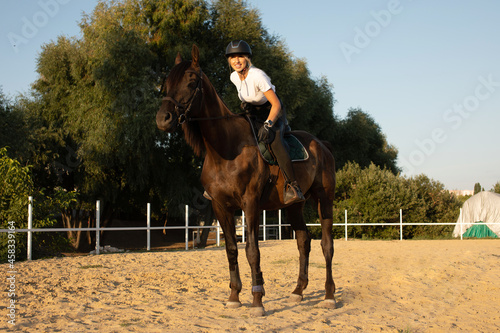 Young woman preparing to become a riding instructor taking care and talking to a horse.