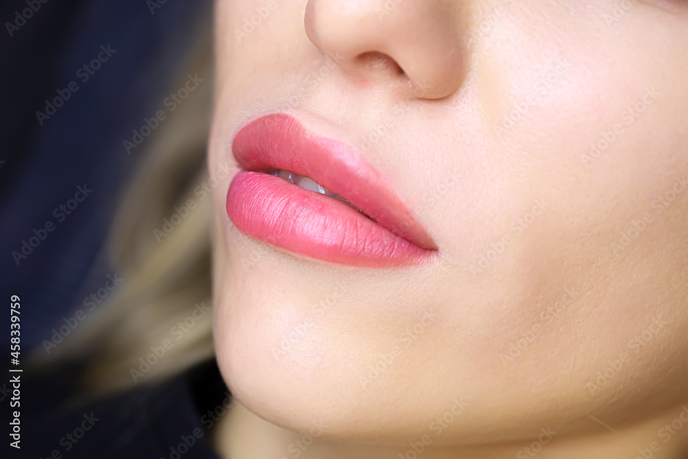 Fototapeta premium close-up of the beautiful lips of a young model with a lip tattoo