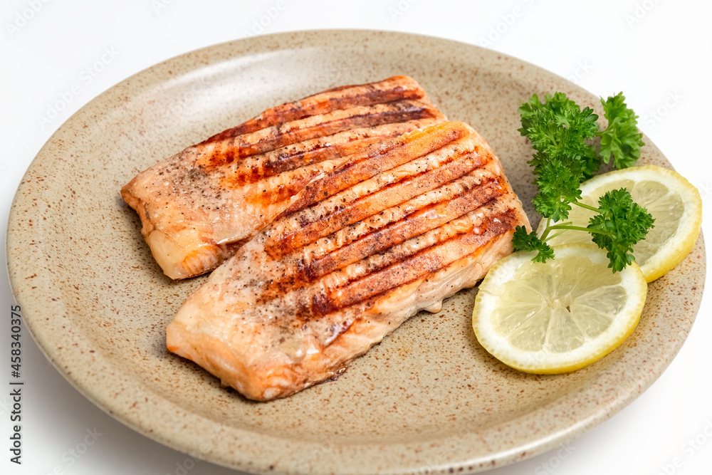 Grilled trout fish and lemon slices on a plate. Healthy, delicious homemade food. Photo Grilled trout fish and lemon slices on a plate. Healthy, delicious homemade food. Photo