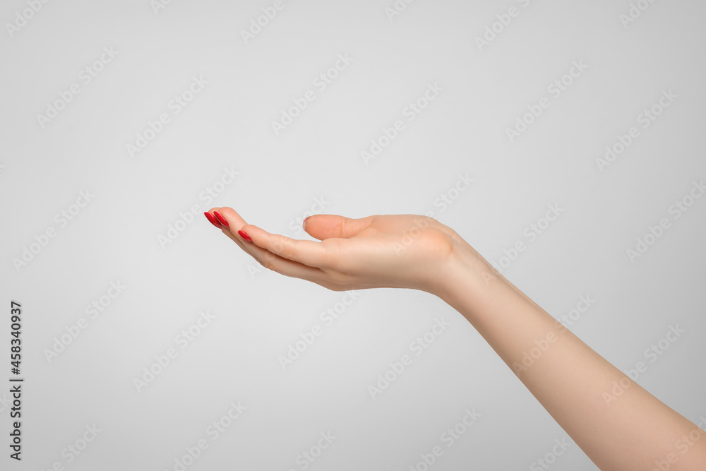 Female hand palm up on gray background