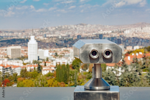 Coin operated binocular viewer at the terrace floor of Atakule in front of blurry Ankara view.