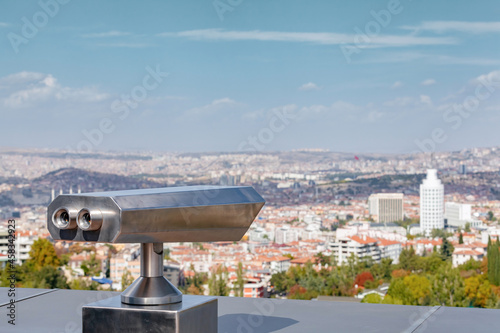 Coin operated binocular viewer at the terrace floor of Atakule in front of blurry Ankara view. photo
