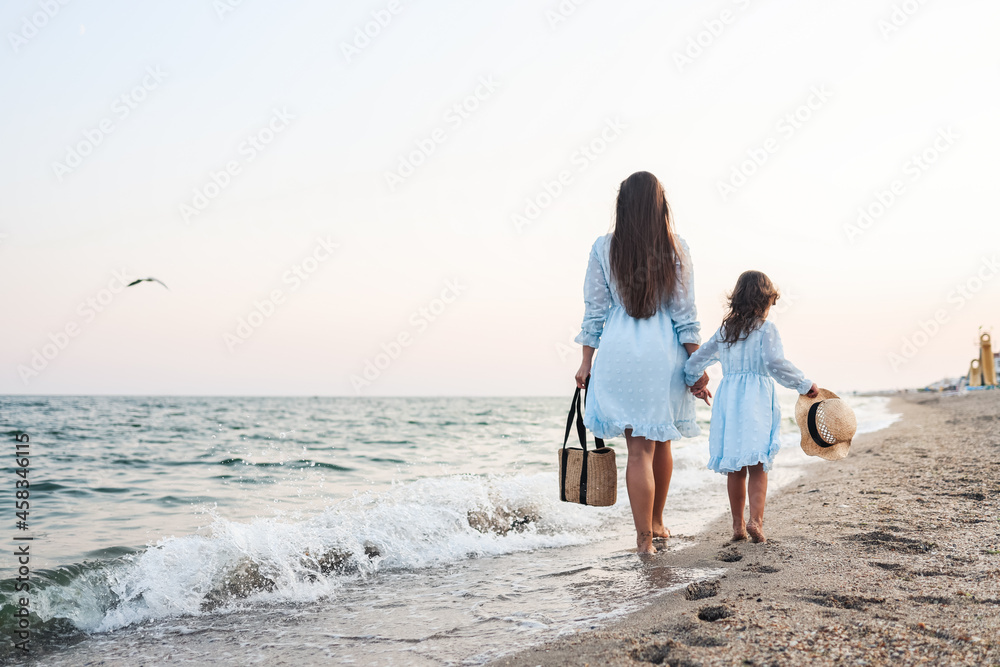 Woman and her little daughter on the beach