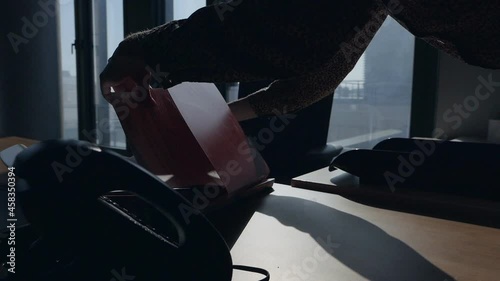 Female spy hands look for the necessary documents in the office and take pictures of secret files by phone
