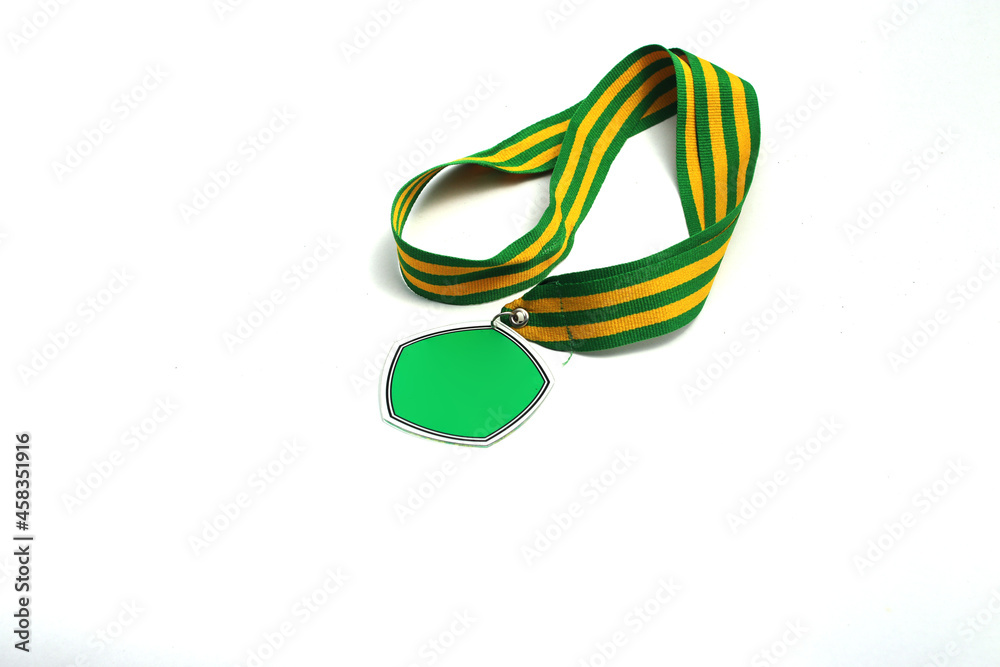 Naklejka premium Graduation medal with the empty green pentagon-shaped medal and green-yellow stripes ribbon isolated on white background. Education, sport, champion, winners concept background stock images.