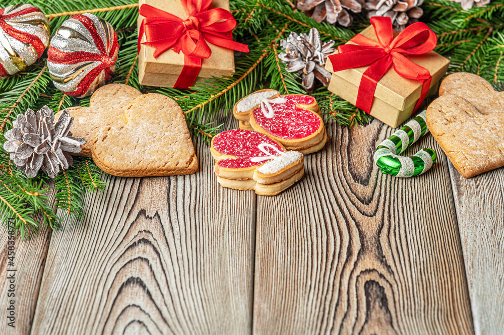 festive christmas and new year background with copy space, fir branches, сhristmas decorations, pine cones, gingerbread cookies and gifts on a vintage wooden table festive christmas and new year background with copy space, fir branches, сhristmas decorations, pine cones, gingerbread cookies and gifts on a vintage wooden table