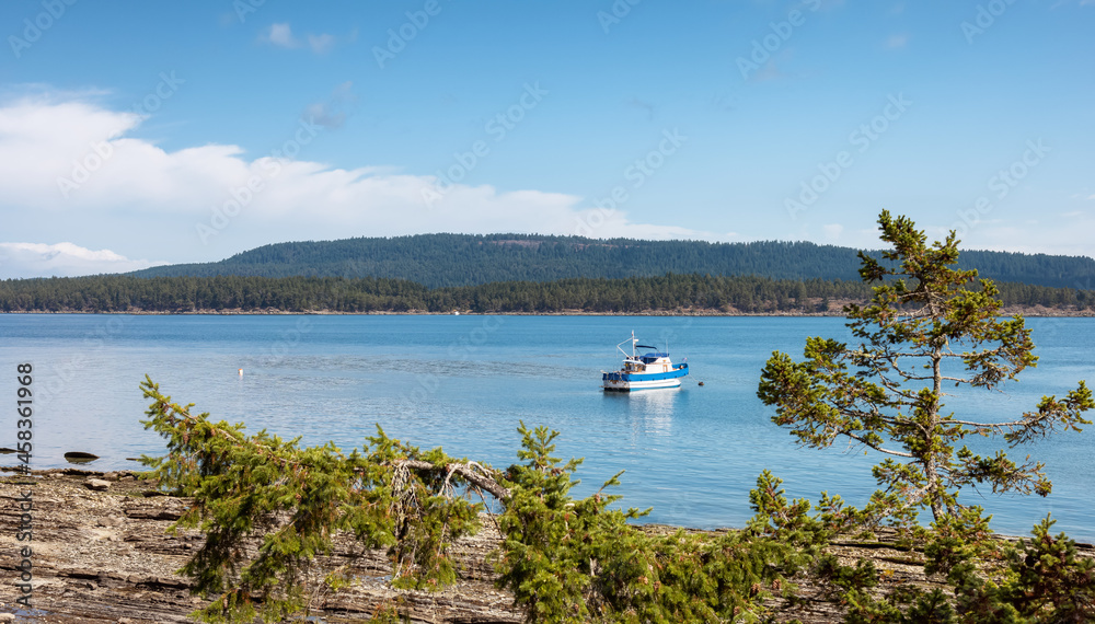 Fishing Boat near the Shore on Pacific Ocean West Coast. Sunny Summer Day. Fernwood Point Beach, Salt Spring Island, British Columbia, Canada. Fishing Boat near the Shore on Pacific Ocean West Coast. Sunny Summer Day. Fernwood Point Beach, Salt Spring Island, British Columbia, Canada.