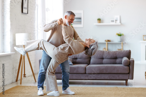 Romantic senior family couple wife and husband dancing to music together in living room © JenkoAtaman