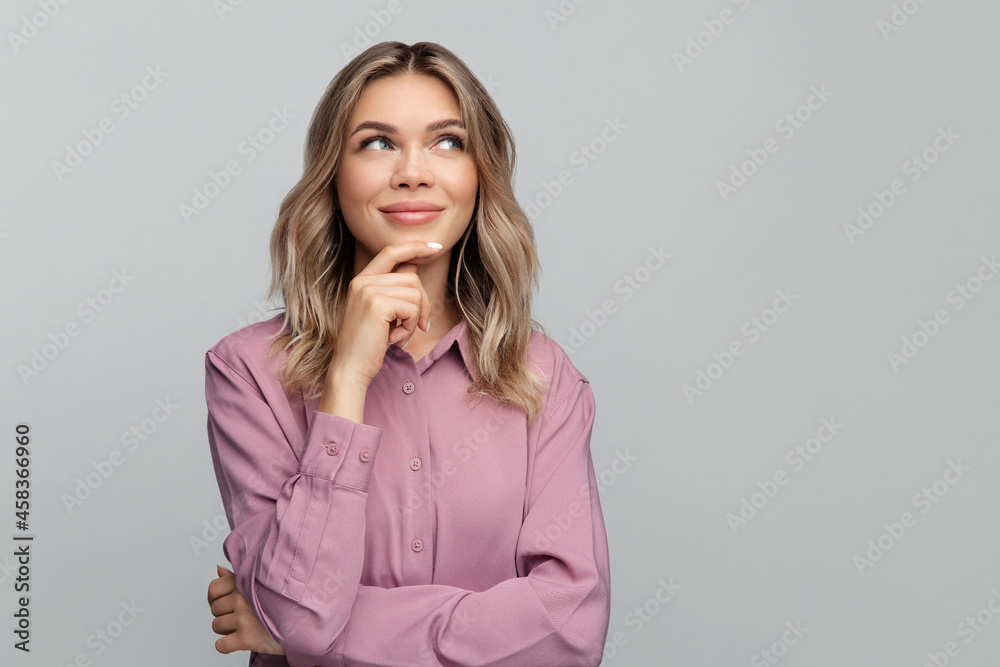 Curious young woman looking up side touching chin while pondering on new idea for business development or thinking of future success. Positive thoughtful female cunning smiling pensive and confident Curious young woman looking up side touching chin while pondering on new idea for business development or thinking of future success. Positive thoughtful female cunning smiling pensive and confident