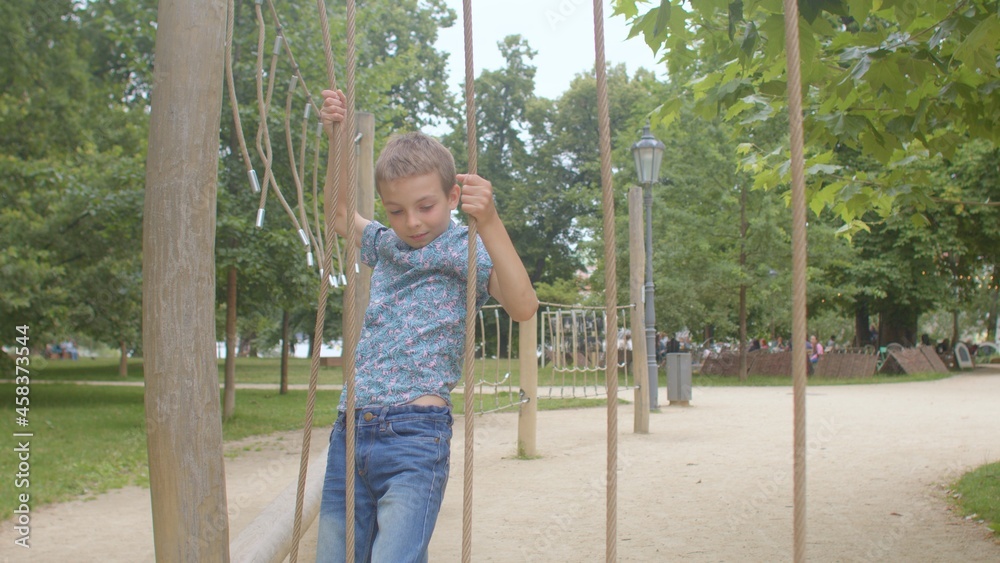 Active play of teenager in a rope court in a forest school. Difficulty wading in ropes. Improving body tone, developing thinking. Active play of teenager in a rope court in a forest school. Difficulty wading in ropes. Improving body tone, developing thinking.