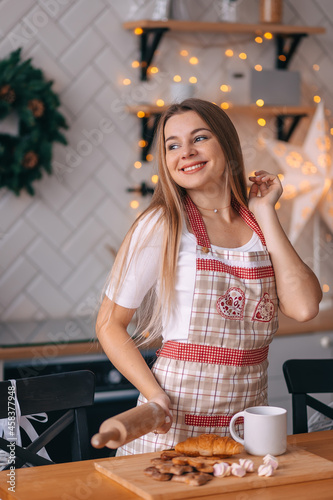 Happy woman prepares Christmas cookies at home. cheerful lady in an apron.