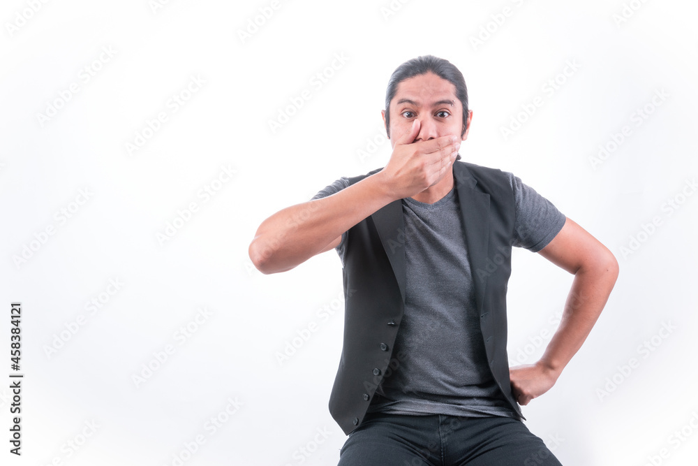 Person with white background, man making gestures, he puts his hand to his mouth as a sign of silence, he does not want to speak and covers his mouth Person with white background, man making gestures, he puts his hand to his mouth as a sign of silence, he does not want to speak and covers his mouth