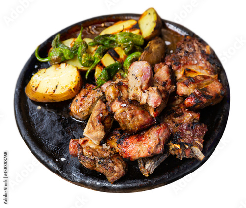 Image of the popular Spanish dish Chuleton of beef steak with bone, served delicious potatoes and pepper in a frying pan. Isolated over white background