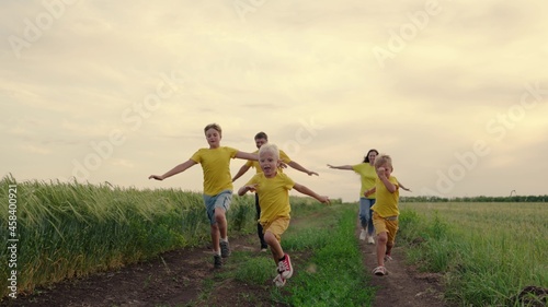 Happy family, children, sons, mom dad run, play, rejoice, enjoy nature in summer. Family teamwork. Family team, running together in field, happily waving their hands. Group of people of different ages