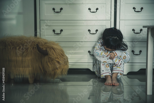 Quadro su tela Sad little girl sitting on floor indoors