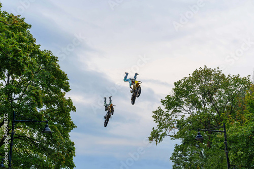 Fotografie Motocross riders perform stunts in the air