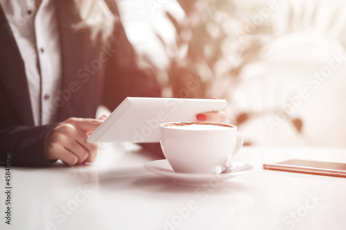 Business woman hands using smart phone and cup of coffee.
