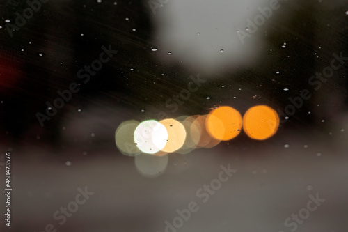 Shot from inside of a vehicle looking through the windshield while passing through traffic during a storm