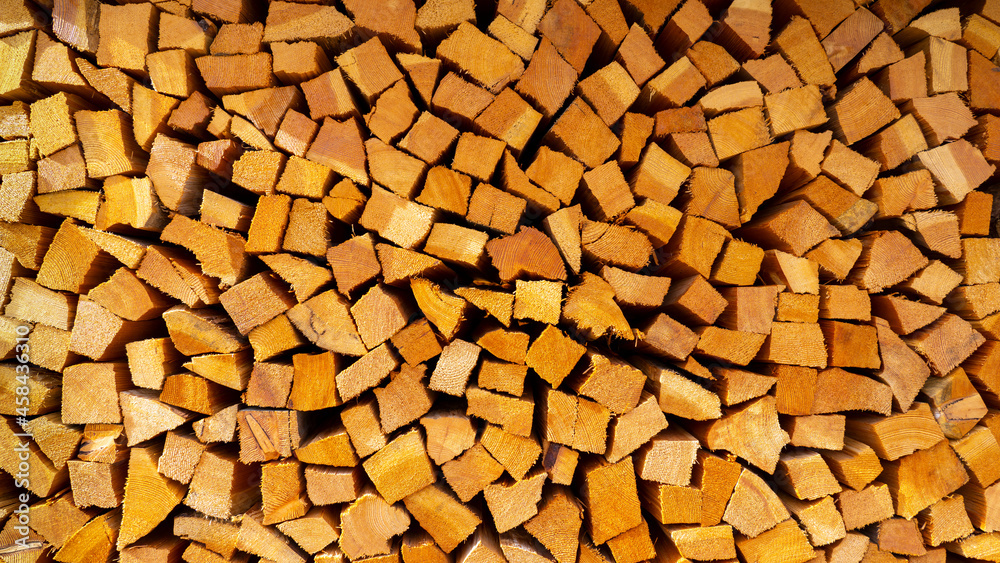 Firewood cut and stacked. Wall of wooden pieces. Warm colors with shades of brown. Wood stacked with precision. Wooden natural cut logs texture background Firewood cut and stacked. Wall of wooden pieces. Warm colors with shades of brown. Wood stacked with precision. Wooden natural cut logs texture background