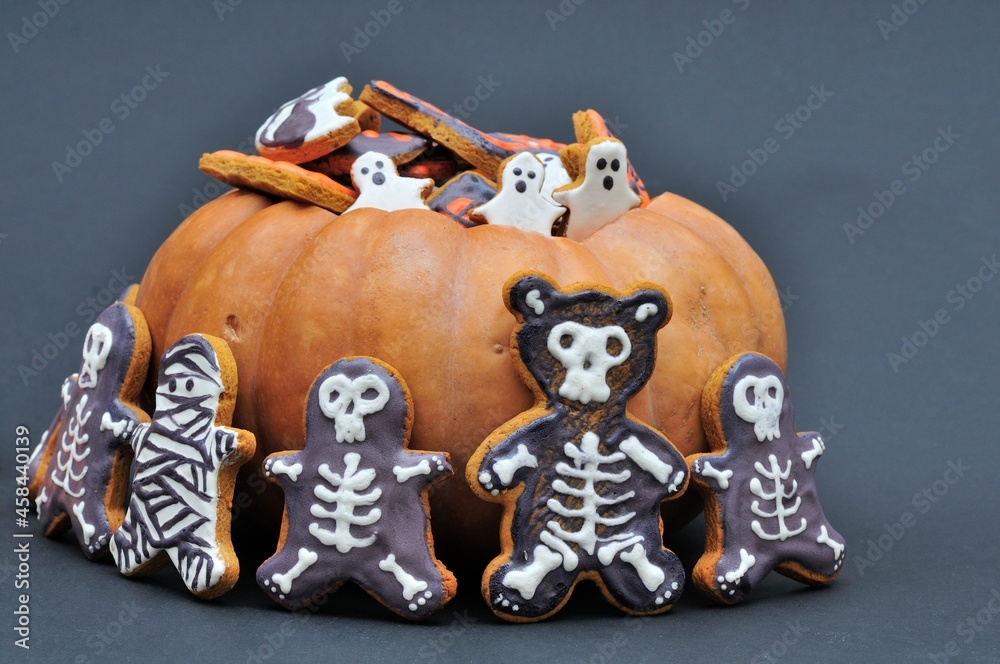 Halloween treat. Gingerbread in pumpkin on dark background.
