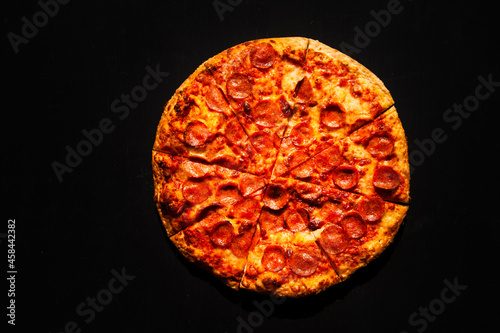 Pepperoni crispy pizza on black background