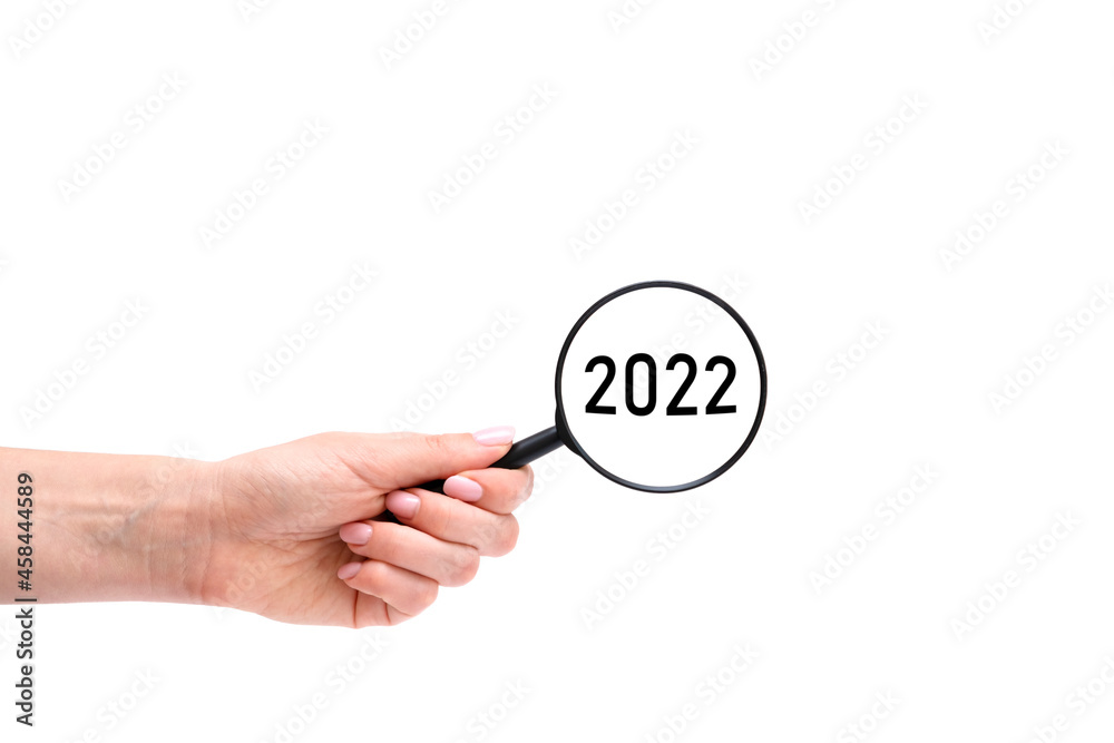 Hand with magnifying glass. 2022 year Hand with magnifying glass. 2022 year