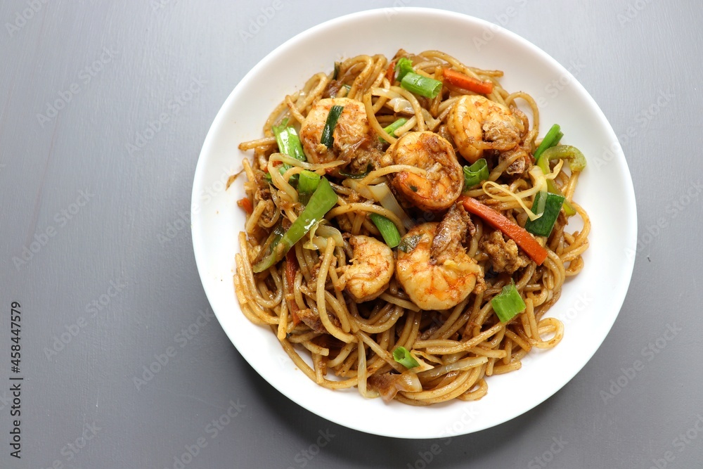 Chinese cuisine, Prawns Chilli garlic noodles. Stir fry noodles with vegetables and shrimp. served in a white plate. Hakka noodles With copy space. Chinese cuisine, Prawns Chilli garlic noodles. Stir fry noodles with vegetables and shrimp. served in a white plate. Hakka noodles With copy space.