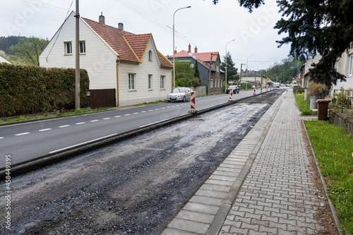 Workman working on new asphalt. Laying the next layer of asphalt in the construction of a new road. Special machinery, construction concept. Paver machine.  © Michal