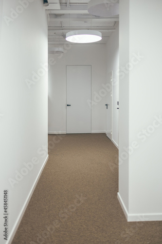 A white corridor  a white door. Beautiful stylish interior.
