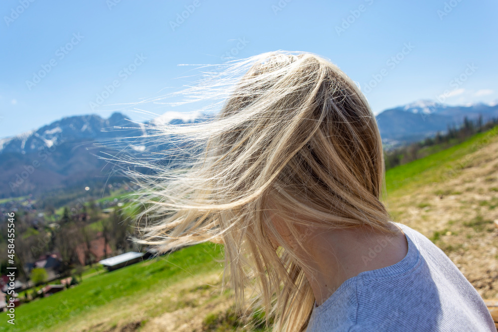 Naklejka premium Kobieta w górach mocny wiatr rozwiał włosy