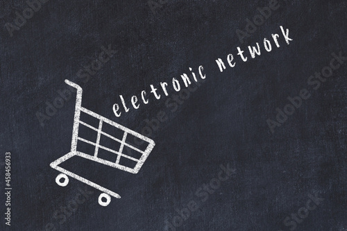 Chalk drawing of shopping cart and word electronic network on black chalboard. Concept of globalization and mass consuming photo