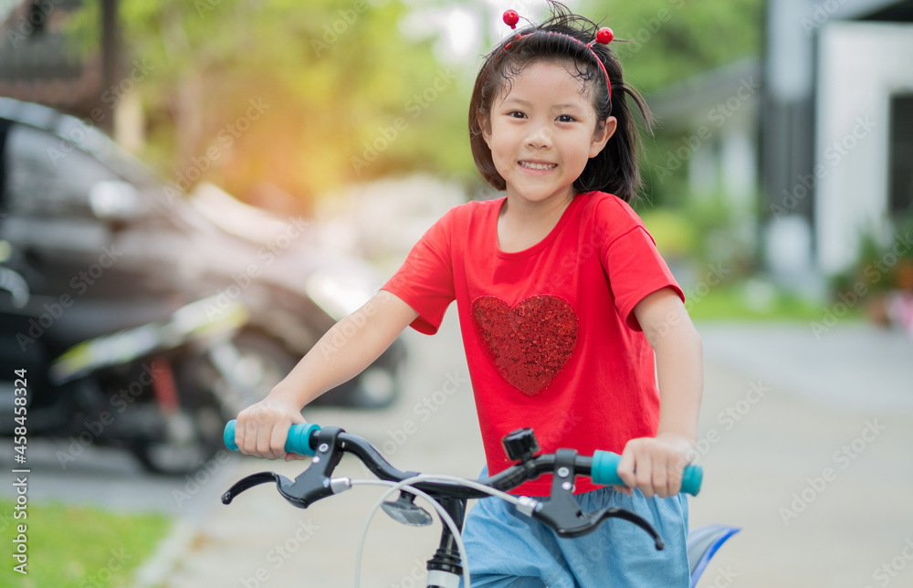 Obraz premium a girl ride a bicycle, kid happy and smile, asian child