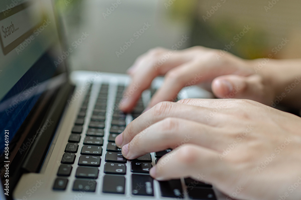Online studying concept the pale hand of a man trying to type on laptop keyboard for searching the definition of a few words that he cannot understand Online studying concept the pale hand of a man trying to type on laptop keyboard for searching the definition of a few words that he cannot understand