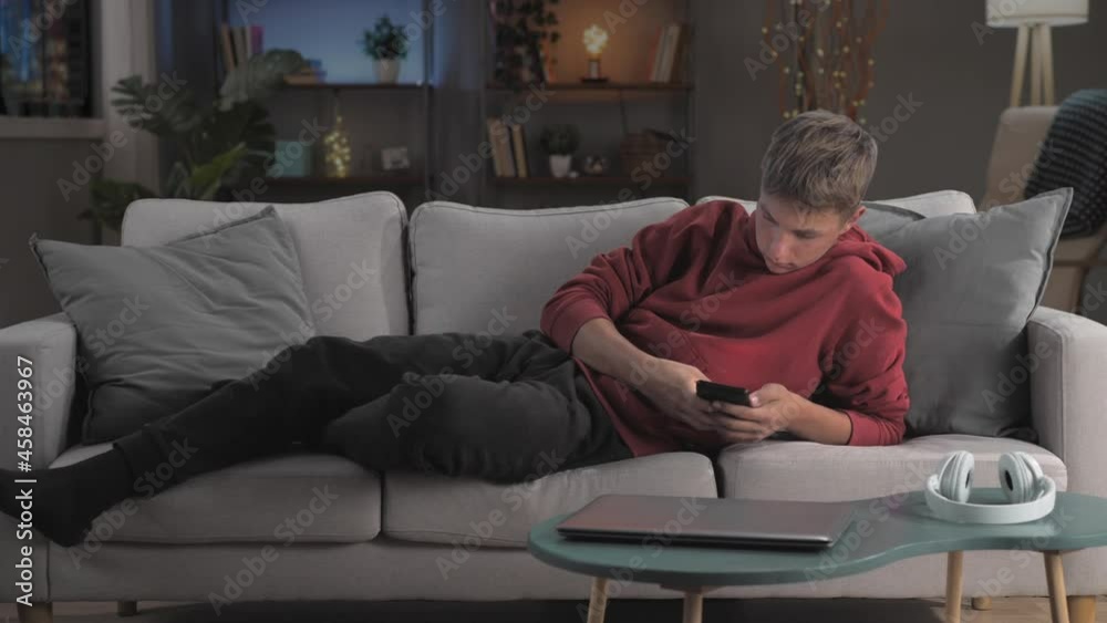 technology addiction boy using smart phone on couch timelapse day to night,smartphone mobile addiction,teenager on sofa uses digital device all day long time lapse
