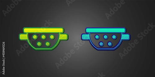 Green and blue Kitchen colander icon isolated on black background. Cooking utensil. Cutlery sign. Vector