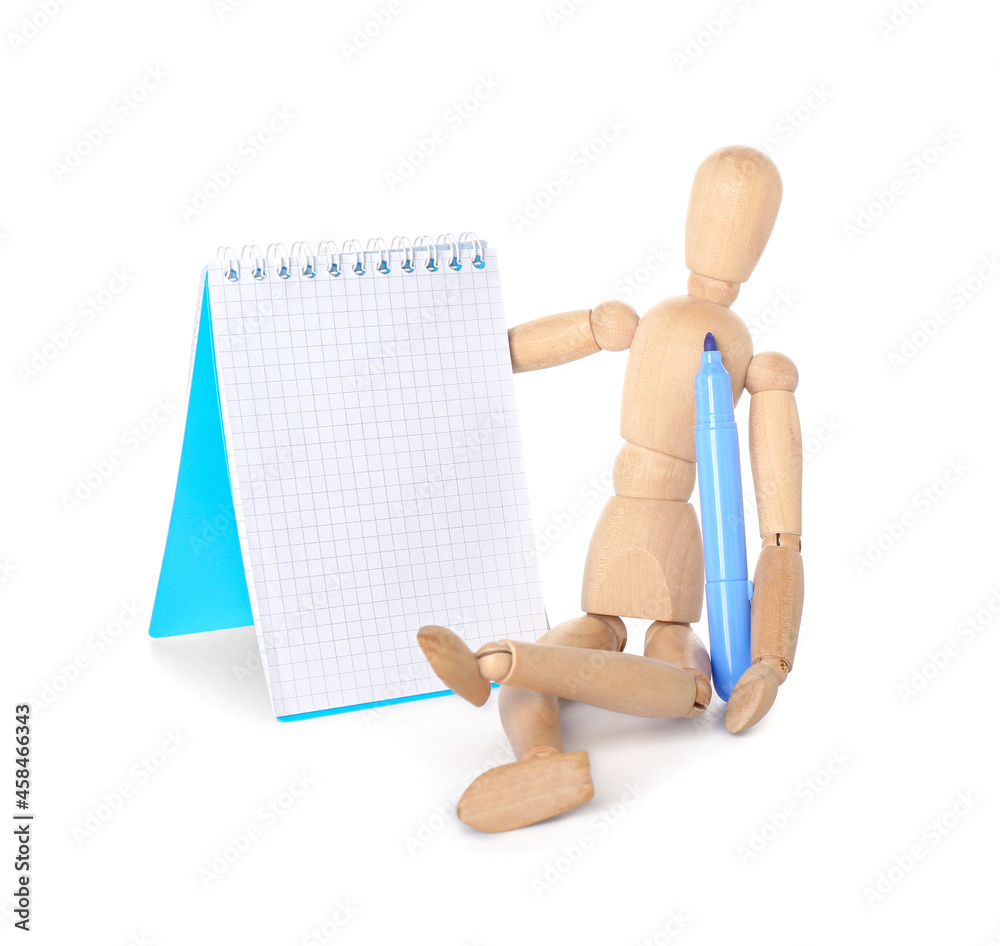 Wooden mannequin with felt-tip pen and notebook on white background Wooden mannequin with felt-tip pen and notebook on white background