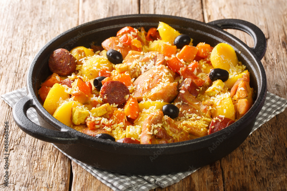 Chinese food Galinha a Portuguesa of chicken with chorizo vegetables in coconut curry close-up in a pan on the table. horizontal Chinese food Galinha a Portuguesa of chicken with chorizo vegetables in coconut curry close-up in a pan on the table. horizontal