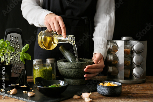 Chef pouring olive oil into...