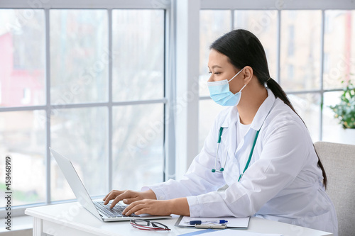 Female Asian doctor using l...