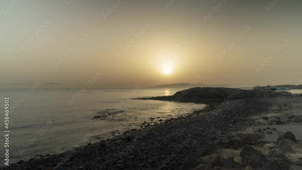 Majestic sun setting down over island of Tenerife with boats passing by
