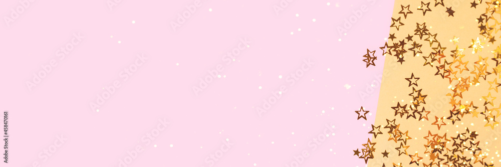 Banner with bright glittering stars confetti scattered on a pink and gold background with copy space. Banner with bright glittering stars confetti scattered on a pink and gold background with copy space.
