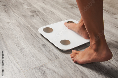 Photography Female leg stepping on floor scales, close-up