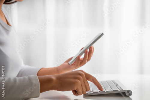 Woman hand enter a one time password for the validation process on laptop, Mobile OTP secure Verification Method, 2-Step authentication web page, Concept cyber security safe data protection business. photo
