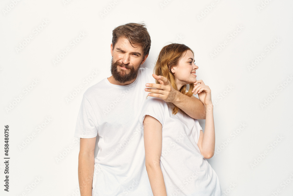 Cheerful man and woman in white t-shirts studio fun posing Cheerful man and woman in white t-shirts studio fun posing