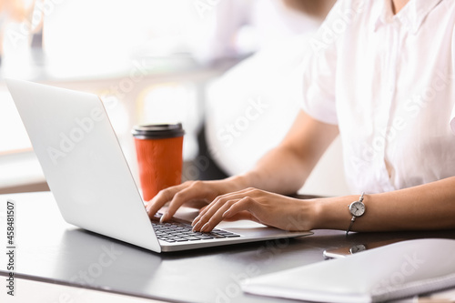 Young woman working on laptop in office, closeup