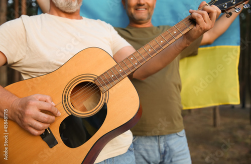Mature man playing guitar a...